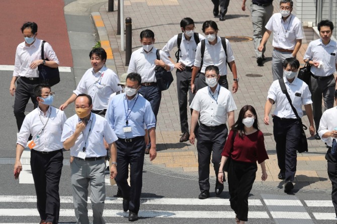 일본 도쿄에서 마스크를 착용한 시민들이 길을 가고 있다.  AP/뉴시스
