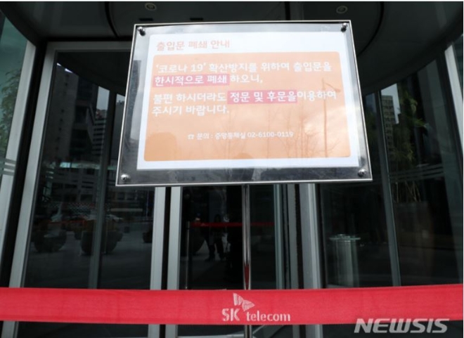 SK텔레콤 직원이 지난 2월 코로나19 1차 검사에서 양성판정을 받은 이후 서울 중구 SK텔레콤 본사 T타워 정문에 출입문 폐쇄 안내문이 설치돼 있다. 사진=뉴시스