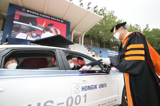 이달 21일 홍익대학교는 드라이브 스루 졸업식을 진행했다. 사진은 졸업생이 차 안에서 총장에게 졸업장을 받고 있는 모습. 사진=뉴시스