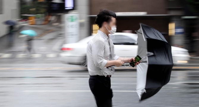 제8호 태풍 '바비'가 우리나라를 지나 북한 지역으로 북상 중인 27일 오전 서울 시내에서 출근길 시민이 우산으로 바람과 비를 막고 있다. 사진=뉴시스