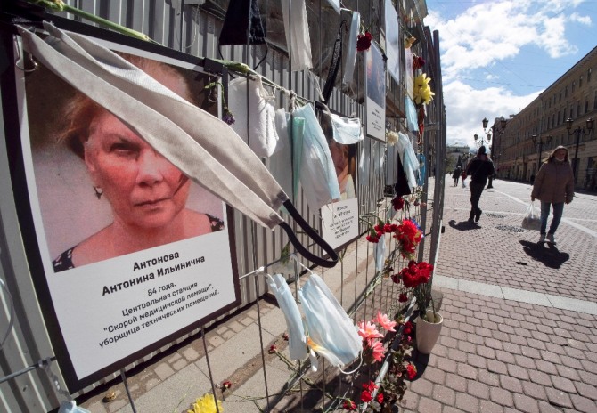 러시아 상트페테르부르크 보건소 앞 추모소에 의료 현장에서 코로나19와 싸우다 감염돼 숨진 의료진의 사진과 마스크가 걸려 있다. AP/뉴시스