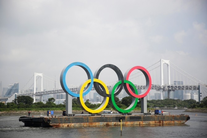 일본 도쿄 오다이바 해양공원 바지선에 설치됐던 2020 도쿄 올림픽&패럴림픽 오륜 조형물이 예인선에 이끌려 이동하고 있다. 사진=뉴시스
