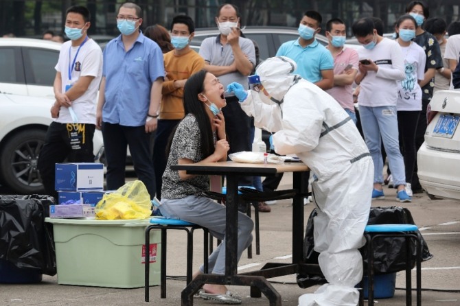 중국 후베이성 우한시 내 한 공장에서 일하는 노동자들이 지난 5월 15일 신종 코로나바이러스 감염증(코로나19) 검사를 받고 있다. 사진=뉴시스/AP