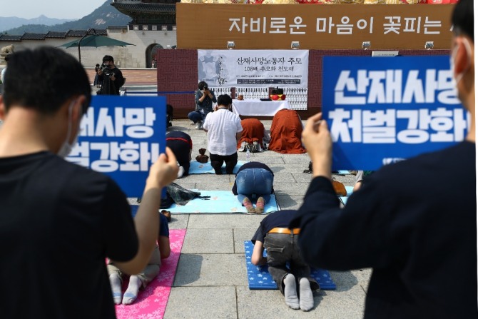 지난 5월 서울 광화문광장에서 열린 2020년 산재사망 노동자 추모의식에서 참석자들이 고인들을 추모하며 절을 하고 있다. 사진=뉴시스