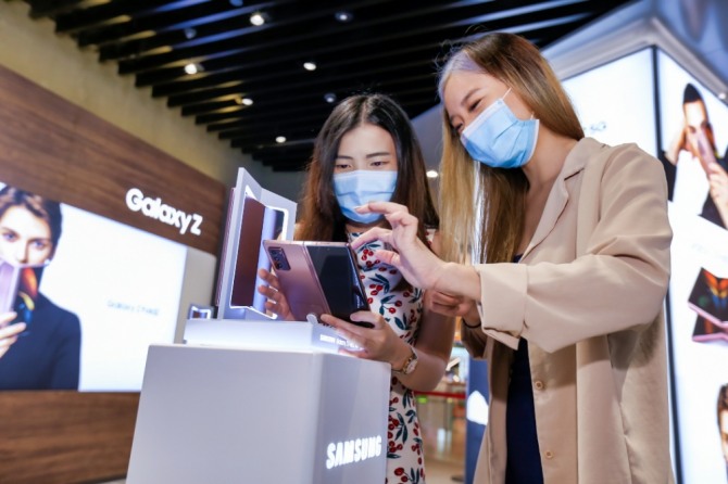 현지 소비자들이 싱가포르의 유명 쇼핑센터 비보시티(ViVo City)에 위치한 삼성 익스피리언스 스토어(Samsung Experience Store)에서 '갤럭시 Z 폴드2'를 체험하고 있다. 사진=삼성전자
