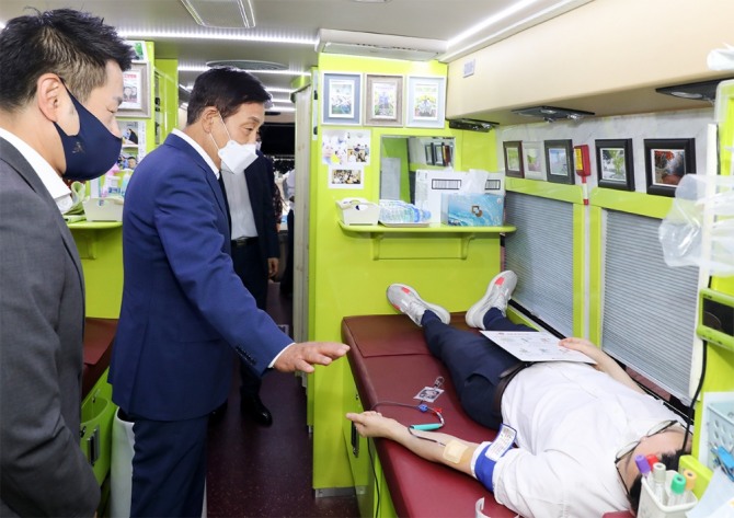 김정태 하나금융그룹 회장(왼쪽에서 두번째)이 17일 하나금융그룹 명동사옥 야외주차장에 마련된 헌혈버스를 찾아 헌혈 캠페인에 참여한 직원을 격려하고 있다. 사진=하나금융그룹