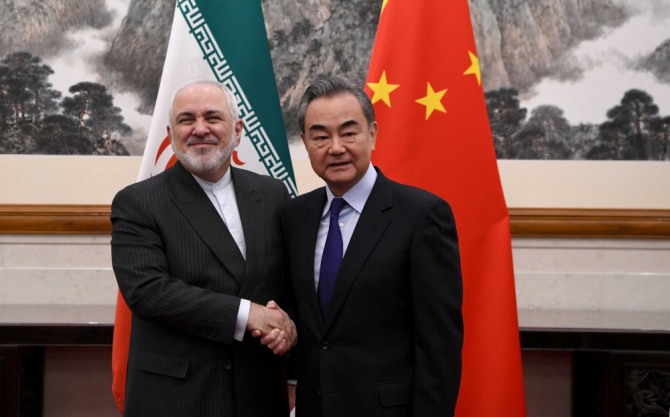 이란과 중국의 외무장관이 악수를 나누고 있다. 사진=로이터