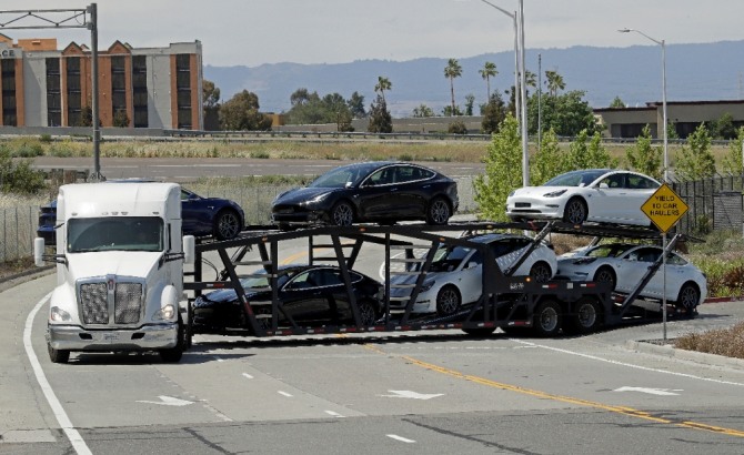 미국 캘리포니아주 프리몬트의 테슬라 자동차 공장에서 트럭 한 대가 신차를 싣고 나오고 있다. 사진=뉴시스