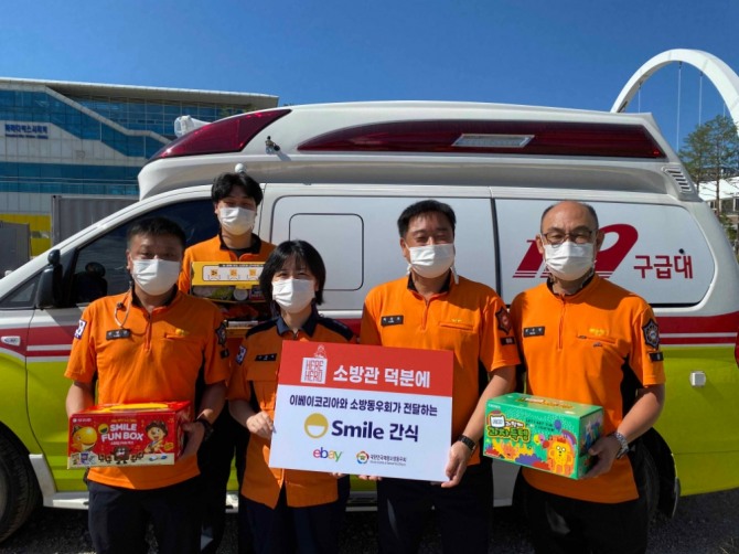 이베이코리아와 소방동우회가 전달한 스마일 간식을 들고 기념촬영을 하고 있는 인천공항 소방관들의 모습. 사진=이베이코리아