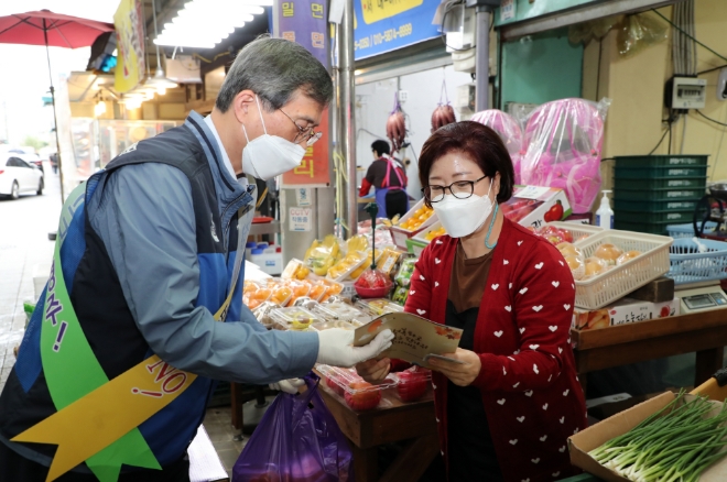 한국수력원자력(한수원) 정재훈 사장(왼쪽)이 23일 경주 전통시장을 방문해 시장상인에게 청렴문화 캠페인 홍보물을 전달하고 있다. 사진=한수원 