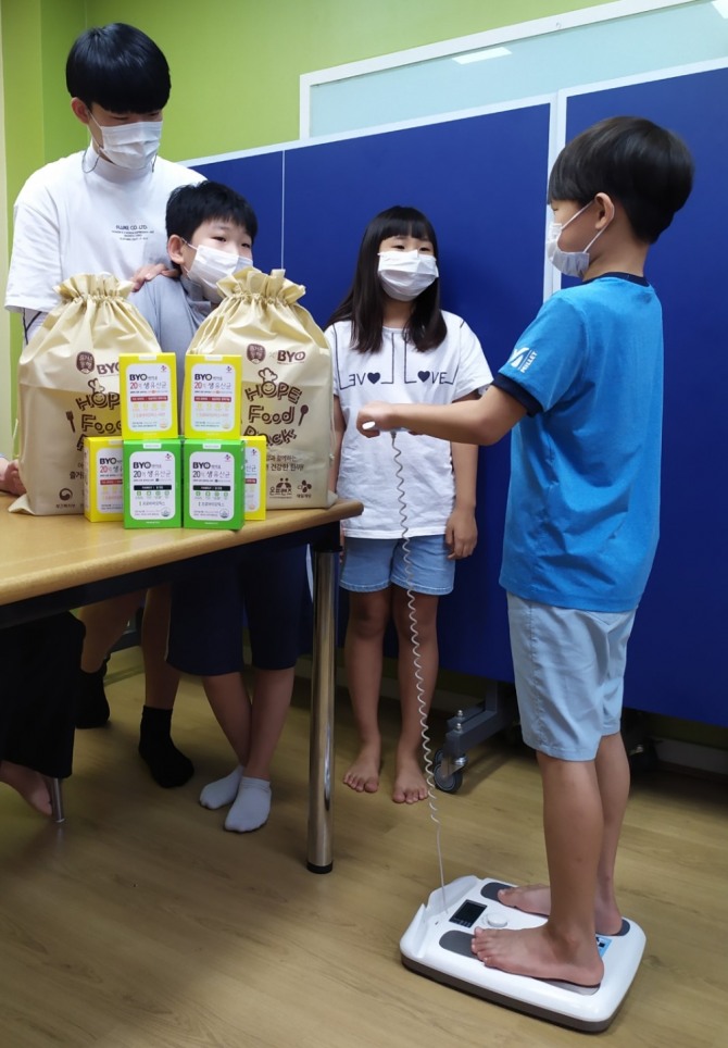 충북 청주지역아동센터 아이들이 신체 계측기에 올라 체중을 재고 있다. 사진=CJ제일제당