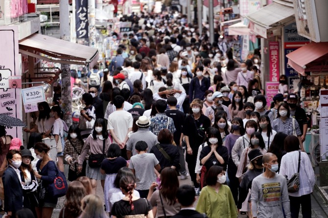 지난달 21일 일본 도쿄의 한 상가에서 마스크를 착용한 사람들이 걷고 있다. AP/뉴시스