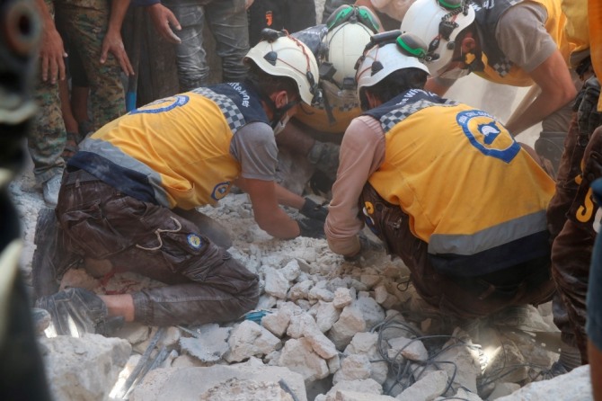 시리아의 하얀 헬멧 민방위대원들이 6일(현지시간) 시리아 북부 알레포 인근 알-바브의 버스정류장 인근에서 발생한 폭탄 트럭 폭발로 무너진 건물에서 희생자들을 구조하고 있다. AP/뉴시스