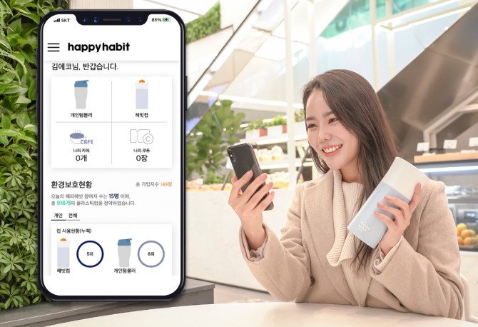 고객이 커피 매장에서 일회용 플라스틱컵 대신 텀블러를 이용하면서 '해피 해빗' 앱을 통해 환경 보호 기여도를 확인하고 있다. 사진=SKT