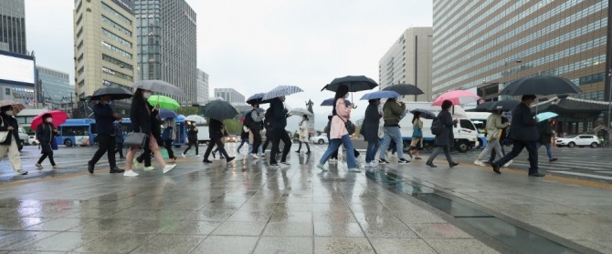 서울 종로구 광화문광장 인근에서 시민들이 우산을 쓰고 걷고 있다. 사진=뉴시스