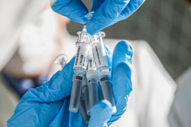 중국 베이징의 시노백 바이오테크에서 한 연구원이 신종 코로나바이러스 감염증(코로나19) 백신 샘플을 보여주고 있다. 사진=뉴시스