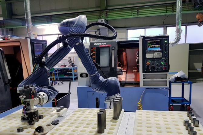 ㈜두산이 협력사 스마트공장 구축을 위해 도입한 협동로봇이 생산현장에서 작업을 수행하고 있다. 사진=(주)두산
