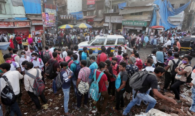 인도 뭄바이에서 노동자들이 일거리를 찾고 있는 동안 순찰차 한 대가 거리를 순찰하고 있다. 사진=뉴시스