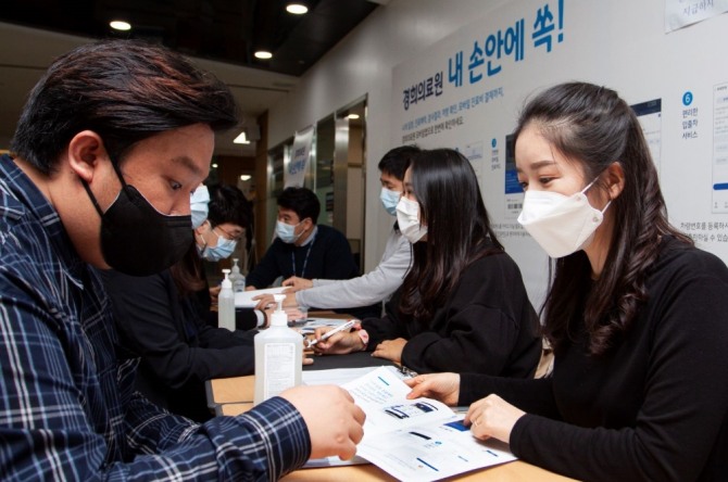 경희의료원 직원이 내원객에게 모바일 앱 설치 및 활용에 대해 안내하고 있다. 사진=경희의료원