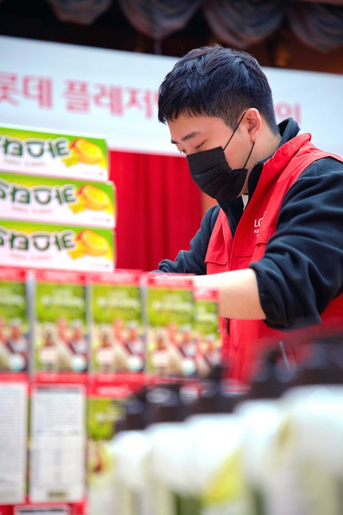 한 봉사자가 9일 전달할 '롯데 플레저박스'를 포장하고 있다. 사진=롯데지주