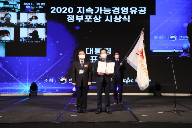 서울 드래곤시티에서 9일 열린 '2020년 지속가능경영유공 정부포상' 시상식에서 SK(주) C&C 안석호 행복추진센터장(오른쪽)과 산업통상자원부 강경성 산업정책실장이 수상 후 기념 촬영하는 모습. 사진=SK C&C