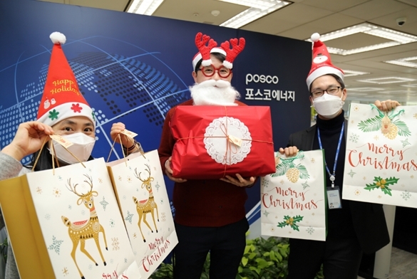 포스코에너지 직원들이 인천 서구 지역아동센터 어린이들에게 ‘맞춤형 크리스마스 선물’을 전달하기 전에 직접 포장한 선물 꾸러미를 들고 깜짝 산타로 변신해 환하게 웃고 있다. 사진=포스코에너지