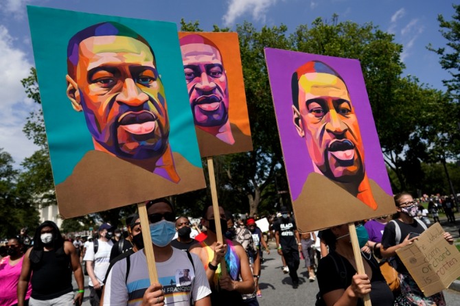 지난 8월 28일(현지시간) 미 워싱턴DC의 링컨 기념관 주변 광장에서 마틴 루서 킹 목사의 '나에겐 꿈이 있다' 연설 57주년을 맞아 인종차별 반대 시위가 열려 참가자들이 조지 플로이드 그림을 들고 있다.사진=뉴시스
