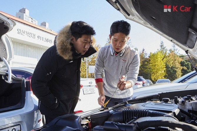 케이카(K Car) 직원(오른쪽)이 고객 자동차 엔진룸을 들여다보고 있다. 사진=케이카