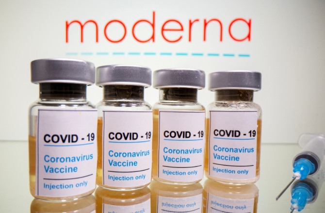 미국 제약사 모더나 로고 앞에 신종 코로나바이러스 감염증(코로나19) 백신이라고 쓰인 병이 있는 이미지. 사진=로이터/연합뉴스 