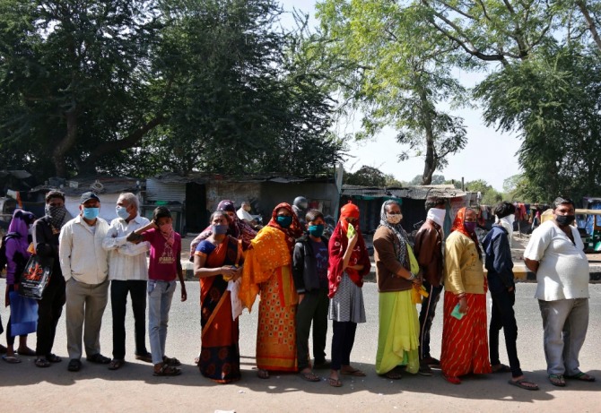 인도 서부 구자라트주 주도에서 사람들이 코로나 19 예방 마스크를 쓰고 은행 앞에서 줄을 서 차례를 기다리고 있다. 사진=뉴시스