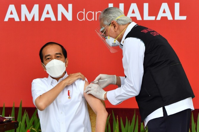 인도네시아 대통령궁이 공개한 사진에 조코 위도도(가운데) 인도네시아 대통령이 지난 13일 자카르타의 메르데카 궁에서 시노백 코로나19 백신을 접종하고 있다. 사진=뉴시스