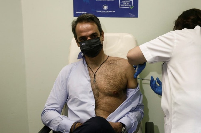 미초타키스 총리가 지난 18일(현지시간) 그리스 아테네 아티콘병원에서 상체를 드러낸 채 2차 코로나 백신을 맞고 있다. 그가 맞은 백신은 화이자가 개발한 백신이다. 사진=로이터