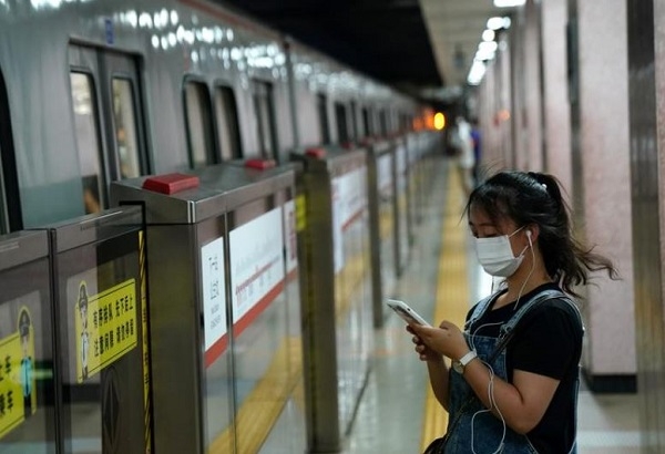 중국 베이징시내 지하철역에서 한 중국여성이 마스크를 쓴 채 스마트폰을 보고 있다. 사진=로이터