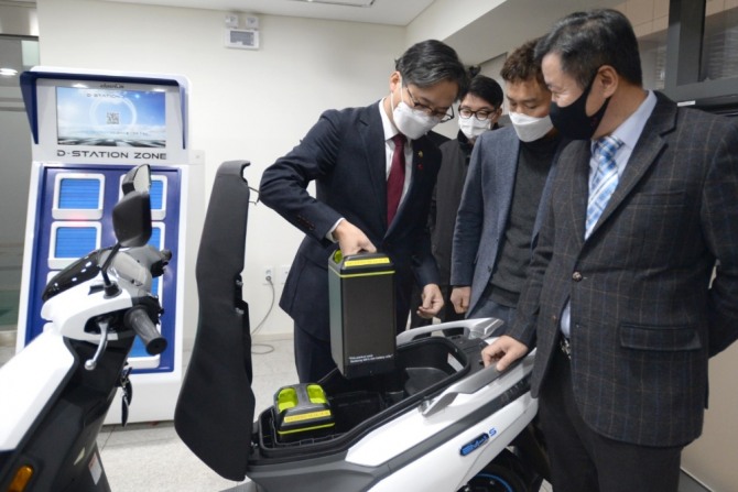 지난 1월 18일 경기도 안양에 있는 전기배터리 개발·제조업체 미섬시스텍을 방문한 산업통상자원부  박진규(맨 왼쪽) 차관과 모빌리티협회, 안양시청, 디앤에이모터스 등 관계자들이 현재 개발 중인 배터리 교환형 충전 플랫폼(BSS)의 준비 상황을 설명 듣고 있다. 사진=디앤에이모터스
