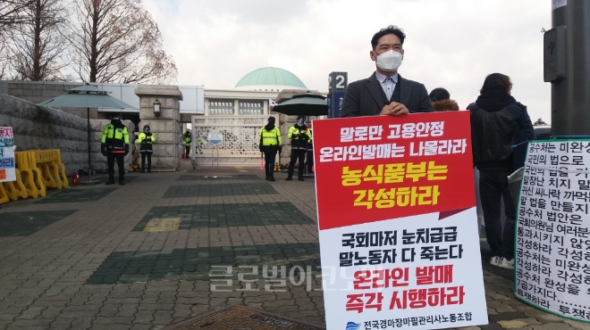 전국경마장마필관리사노동조합 신동원 위원장이 15일 서울 여의도 국회 정문 앞에서 '온라인 발매 즉각 시행하라'는 내용의 팻말을 들고 1인 시위를 하고 있다. 사진=김철훈 기자 