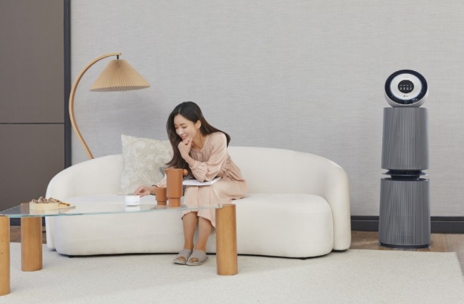  LG전자 모델이 퓨리케어 360˚ 공기청정기 알파(사진 오른쪽)와 연동해 사용하는 인공지능 센서를 소개하고 있다.사진=LG전자