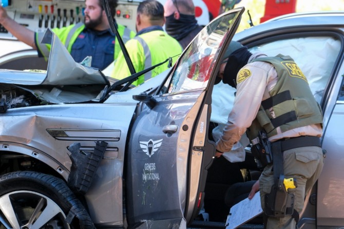 미국 프로 골프 선수 타이거 우즈가 23일(현지시간) 캘리포니아주 로스앤젤레스에서 차량 전복 사고를 당했다. 현지 경찰관이 사고 차량인 제네시스 'GV80'을 살펴보고 있다. 사진=AP/뉴시스