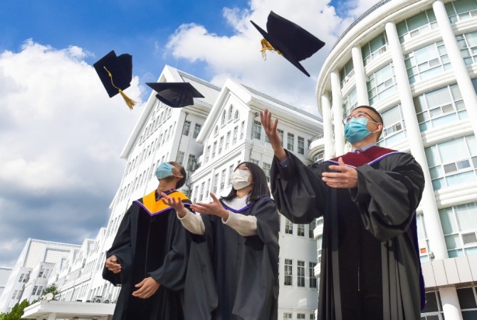 조선대학교 외국인 유학생들이 2020학년도 전기 학사학위기를 수여받은 후 학위복을 착용하고 조선대학교를 상징하는 본관 건물 앞에서 졸업 사진을 찍고 있다./조선대=제공