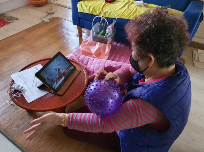 한 어르신이 태블릿 PC 활용 중 운동을  재택에서 스스로 프로그램을 따라하고 있다. (사진=계양구 제공)