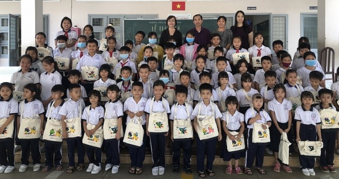 신한파이낸스베트남 관계자들과 베트남 도안초등학교 학생들이 기념촬영을 하고 있다. 사진=베트남 콩뚜옹(Cong Thuong) 홈페이지