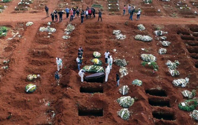 브라질 상파울루의 한 공동묘지에서 묘지 관계자들이 코로나19 합병증으로 숨진 사람의 관을 매장하고 있다. 사진=뉴시스