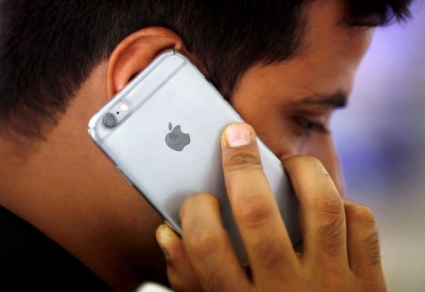 한 인도 남성이 인도 뉴델리의 모바일스토어에서 애플 아이폰으로 전화하는 모습. 사진=로이터