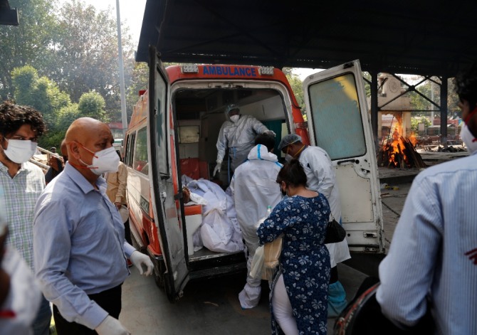 인도 뉴델리의 한 화장터에서 보건 인력들이 6구의 코로나19 사망자 시신을 구급차에서 내리고 있다. 사진=뉴시스