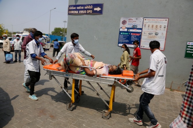 지난달 27일(현지시간) 인도 아마다바드에서 보건 종사자들이 코로나19 환자를 들것에 실어 코로나19 전용 국립 병원으로 이송하고 있다. 사진=뉴시스