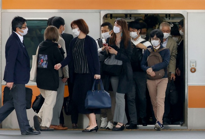 지난 6일 일본 도쿄의 한 역 열차에서 마스크를 쓴 통근자들이 내리고 있다. 사진=뉴시스