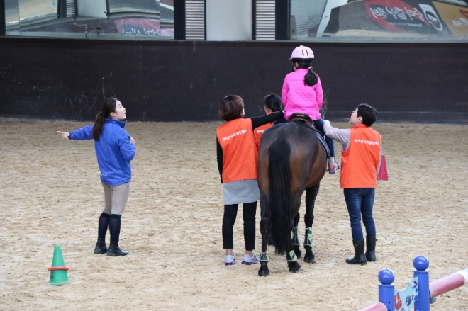 한국마사회 관계자들이 장애 어린이를 위해 재활승마 프로그램을 진행하고 있다. 사진=한국마사회 