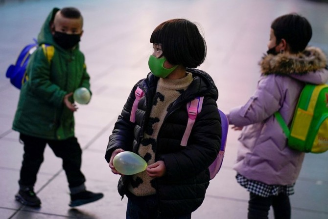 마스크를 쓴 중국 어린이들이 지난 5일(현지시간) 상하이역 역사에서 부모와 함께 열차를 기다리고 있다. 사진=로이터