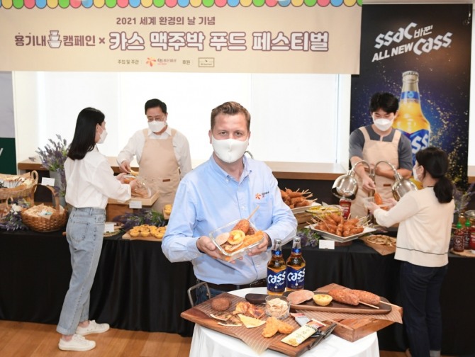 배하준 오비맥주 대표(맨 앞쪽)가 '카스 맥주박 업사이클링 푸드 페스티벌'에서 직접 챙겨온 용기에 맥주박 푸드를 담고 기념 촬영을 하고 있다. 사진=오비맥주