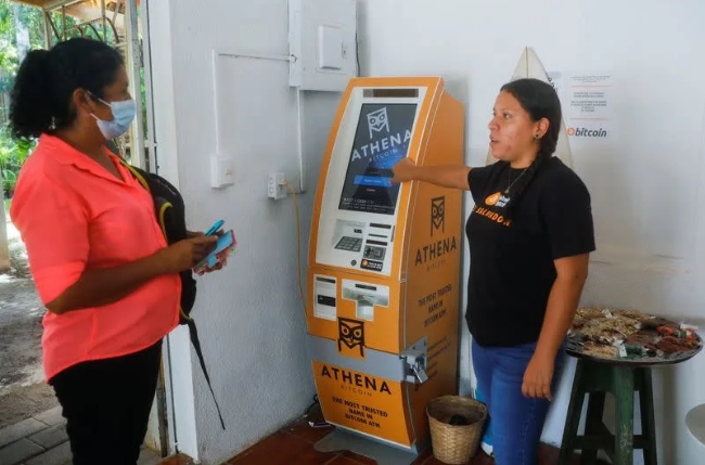 엘살바도르가 비트코인을 합법적 통화로 채택한 첫날 한 여성이 결제 ATM기 앞에서 관리자에게 설명을 듣고 있다.