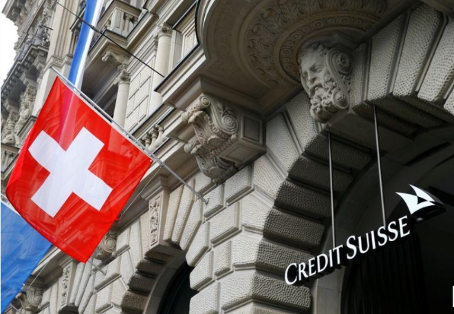 스위스 국기가 취리히 퍼레이드플라츠 광장에 있는 스위스 은행 크레디트 스위스 로고 옆에 나부끼고 있다.          사진=로이터